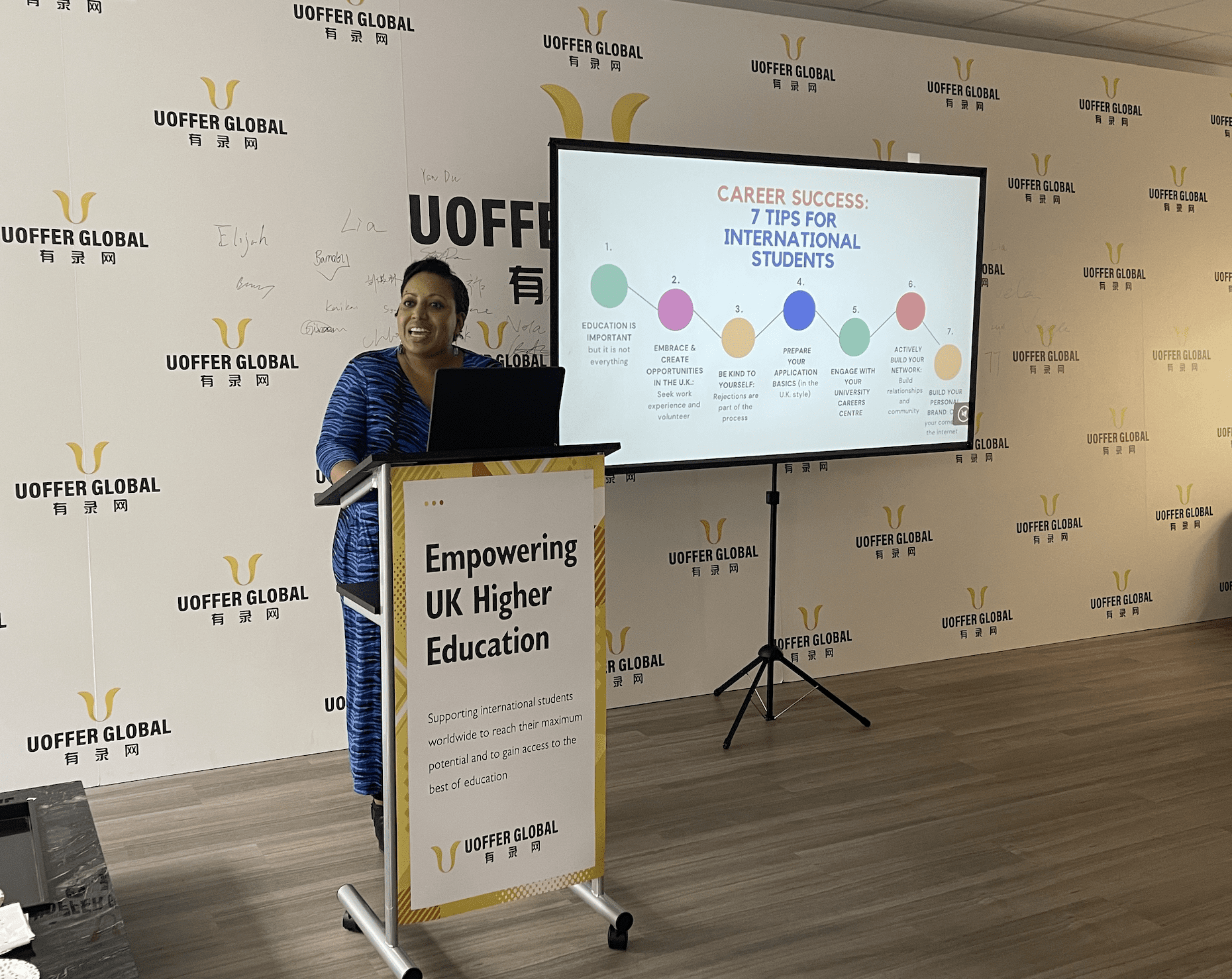 Gina standing at a podium and speaking at UOffer event 2024