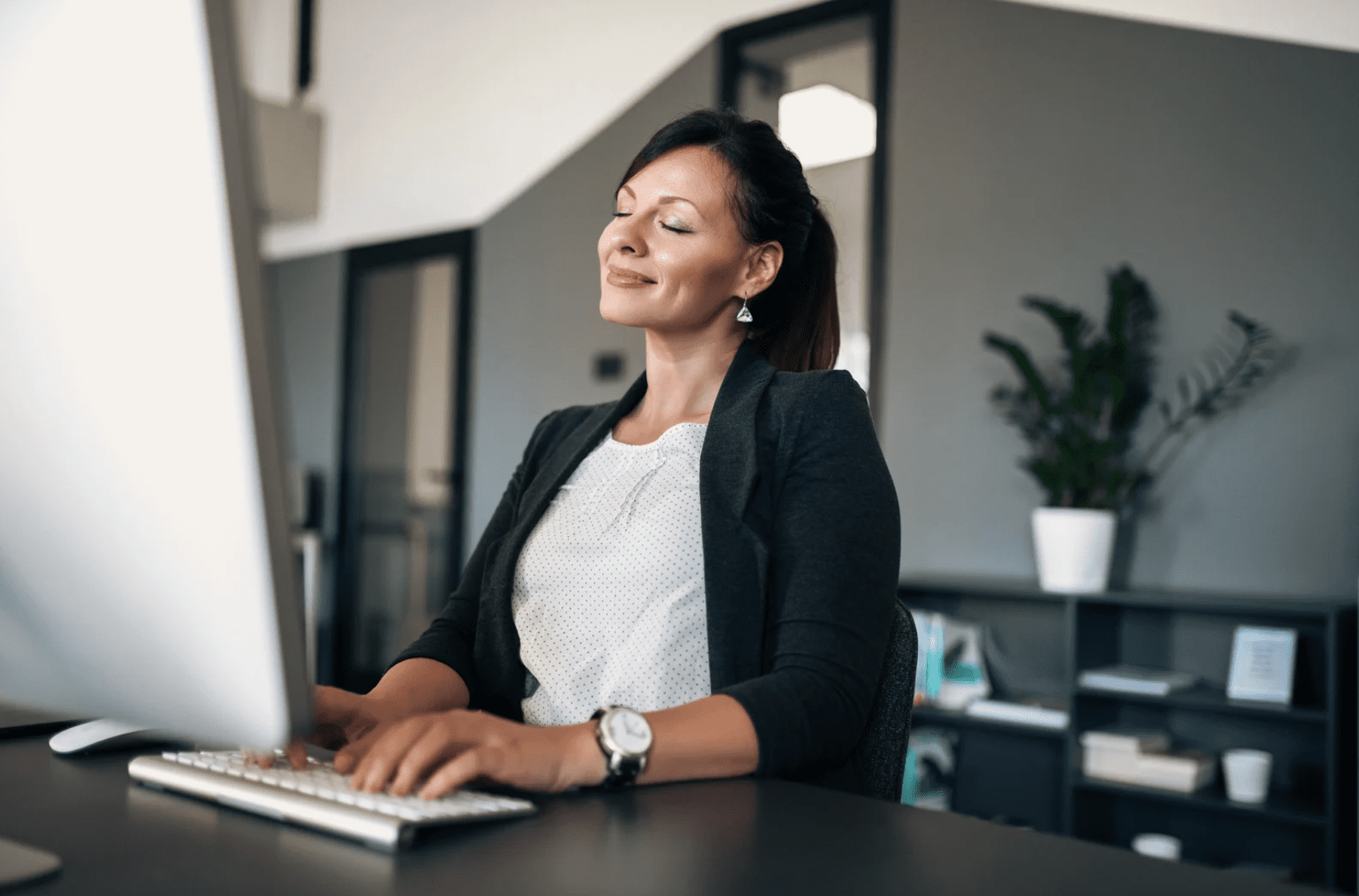 Woman sitting at desk in front of her computer in the office